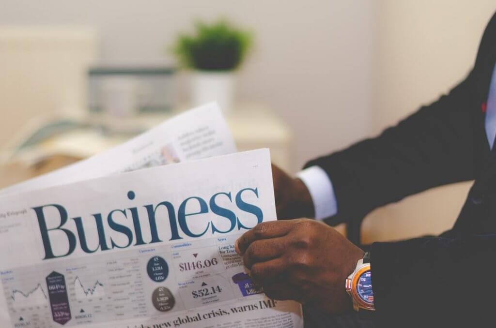 man reading business journal newspaper